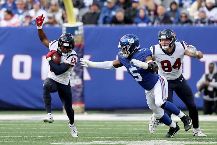 wide receiver Brandin Cooks runs with the ball as Kayvon Thibodeaux reaches for him